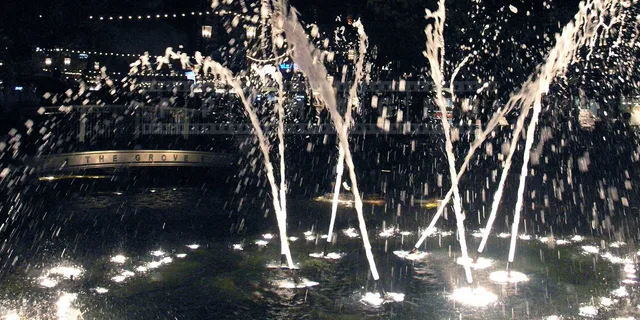 Lovely fountain at night and the grove sign