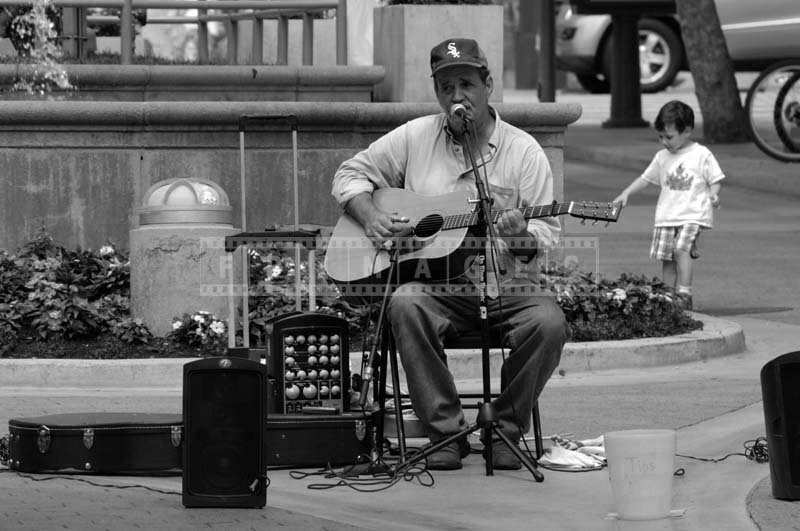 A Street Musician Singing and Playing the Guitar