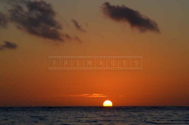 Clear horizon line and the sun appearing above it at sunrise