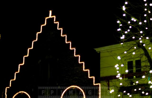 Old building roof decorations at night in Bruges