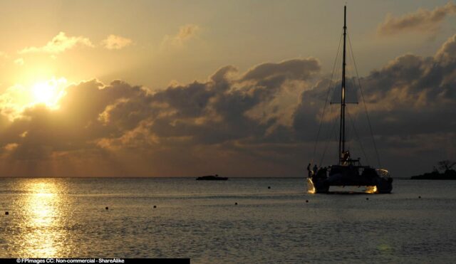 Romantic catamaran cruise during amazing tropical sunset on Bloody Bay