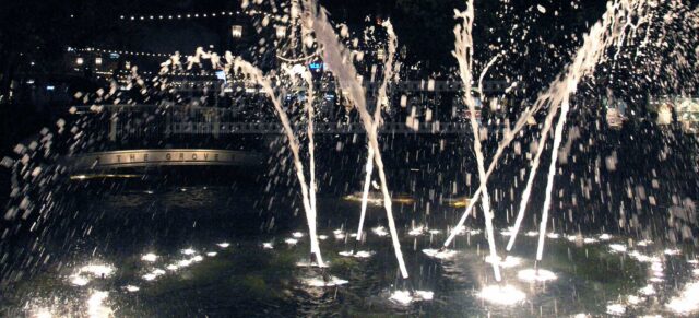 Lovely fountain at night and the grove sign