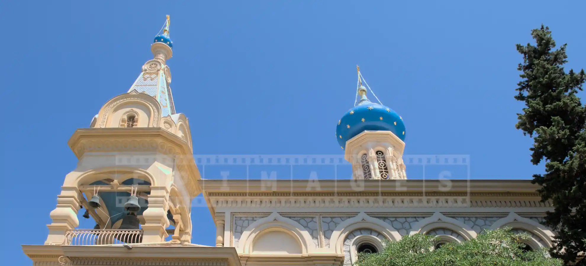 Pretty bell tower with small dome and a larger blue dome with golden stars