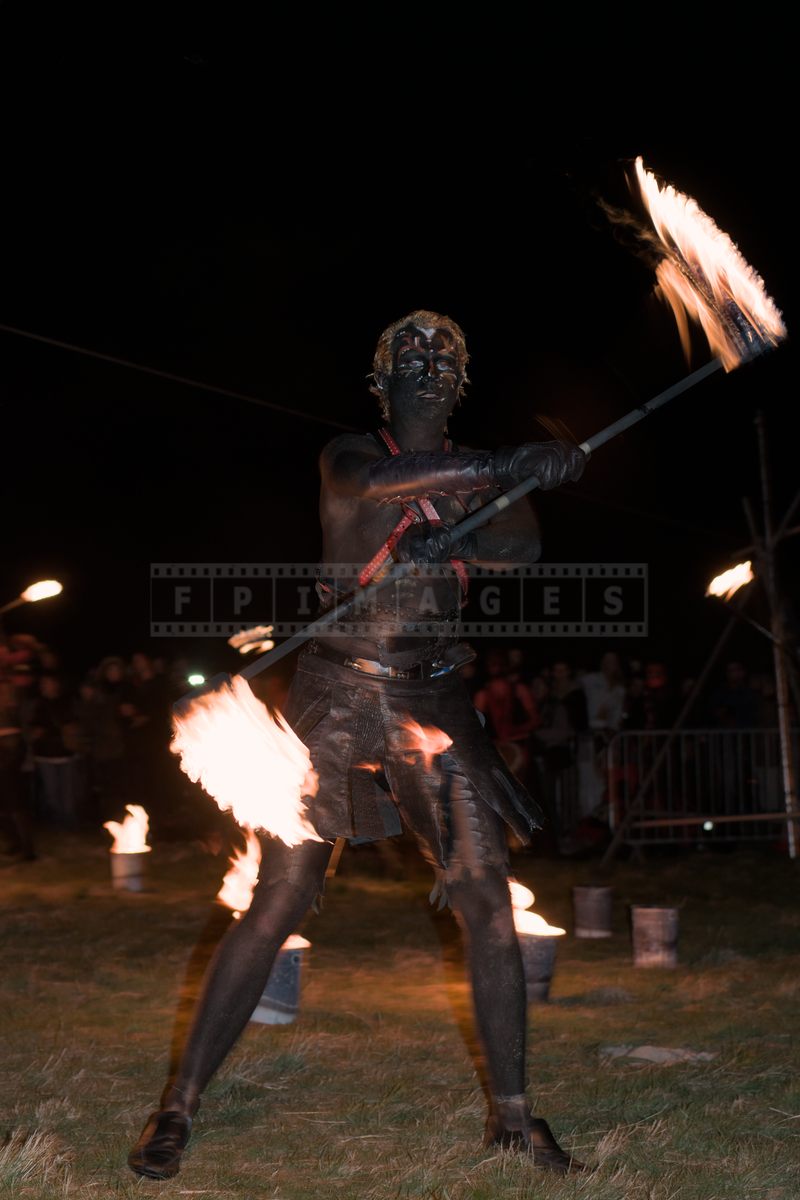 fire artist juggling the fire stick called fire staff