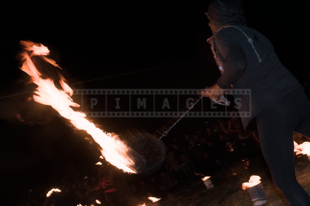 Long trace of fire from a fire meteor on a long chain being swung around