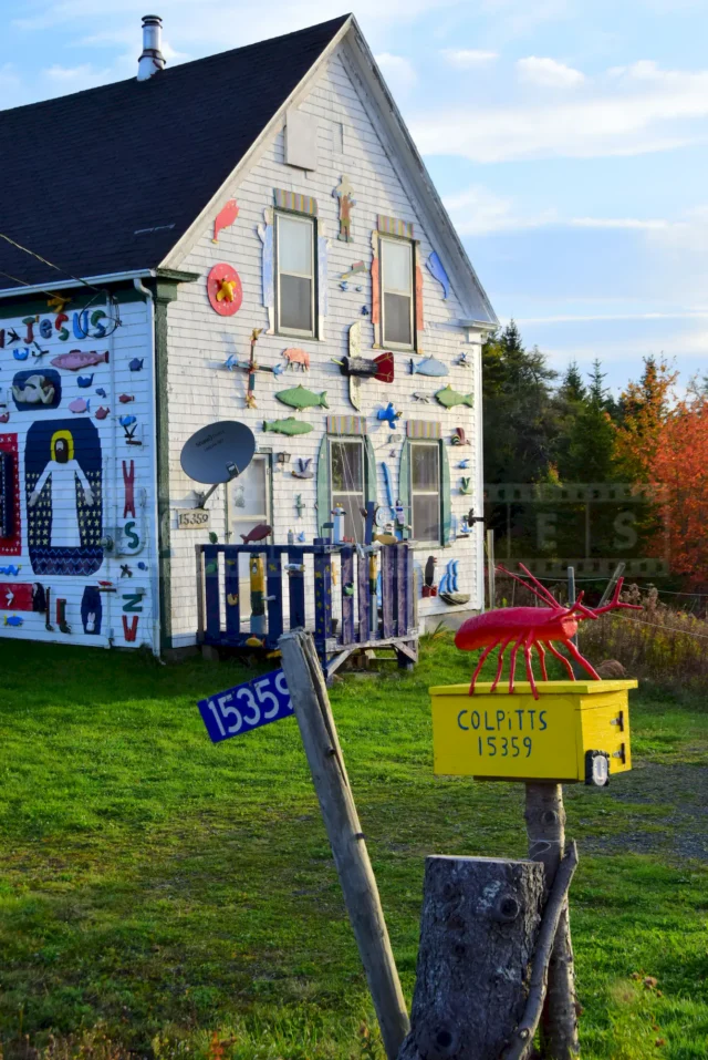 Colpitts' house mailbox with red lobster and the facade displaying other folk art.