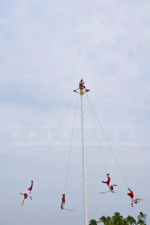 Voladores de Papantla - bird-men hanging from 90 foot pole in a ritual dance to the tune played on flute.
