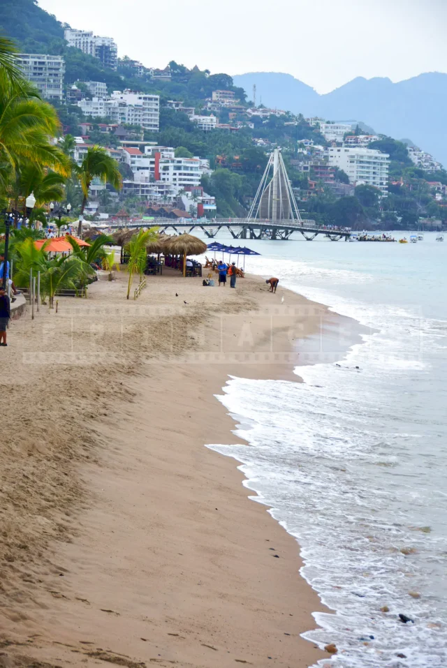 a view of Puerto Vallarta hilly coast, the beach and a restaurant