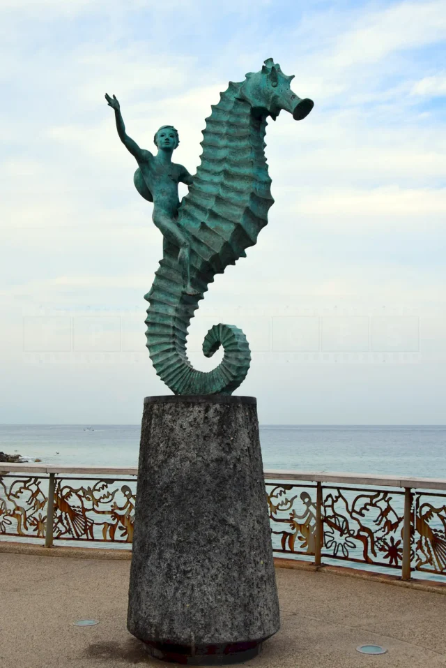 A boy riding a seahorse statue