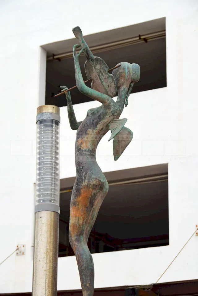 side view of the mermaid playing the violin